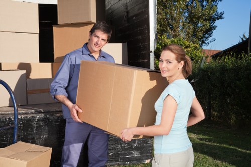 Movers carrying furniture from a Brockley flat